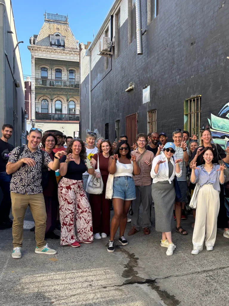 Group of friends posing in front of street art
